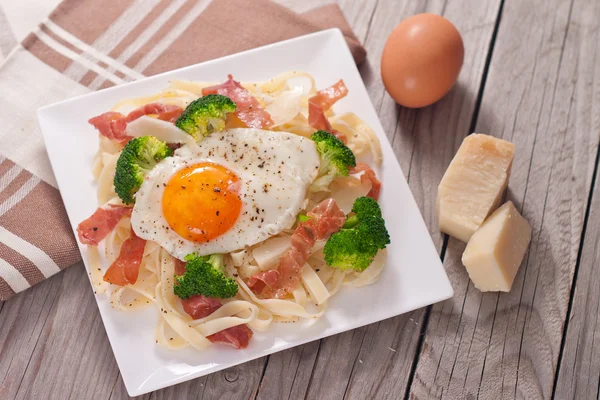 Pasta de tagliatelle con brócoli, jamón y huevo frito . — Foto de Stock