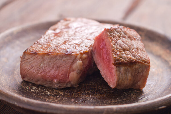 Rare beef steak on rustik plate