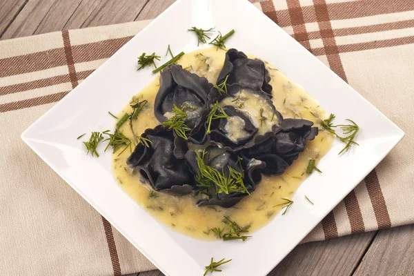 Black ravioli stuffed salmon with dill mustard sauce — Stock Photo, Image