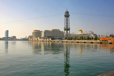 Liman boyunca seyir terminaline doğru bakın, yolcu gemileri kenetlenmiş, teleferik kulesi ve Akdeniz 'de yansımalar güzel bir yaz günü, Barcelona, Katalonya, İspanya.