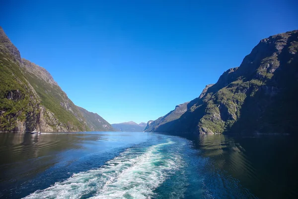 当你沿着海市蜃楼滑行的时候 醒来的船 挪威峡湾 美丽的风景 陡峭的悬崖 夏日平静的水面上反射着群山的倒影 — 图库照片