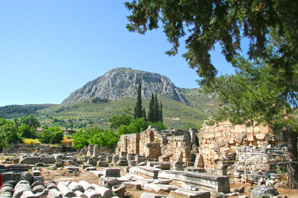 Коринфские колонны сидят среди руин в Коринфе, Греция
.