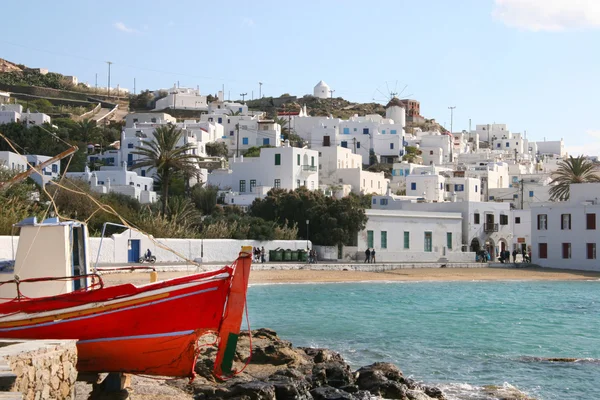 Mykonos stad på en vacker solig dag med en röd fiskebåt i — Stockfoto