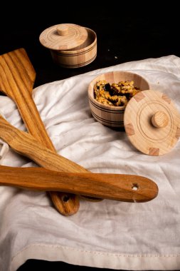 Ahşap mutfak spatulaları, baharat kabı, siyah arka plan, limon, beyaz bez.