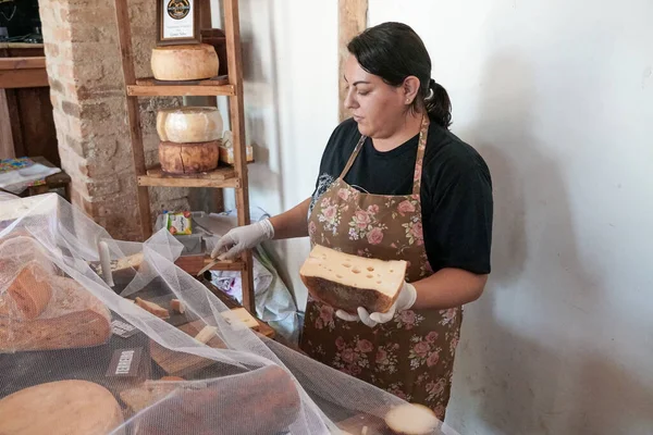 Vendedor sirviendo variedad de queso tradicional en una tienda de quesos — Foto de Stock