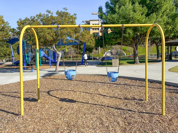 Гойдалки на дитячих ігрових майданчиках в громадському парку — стокове фото