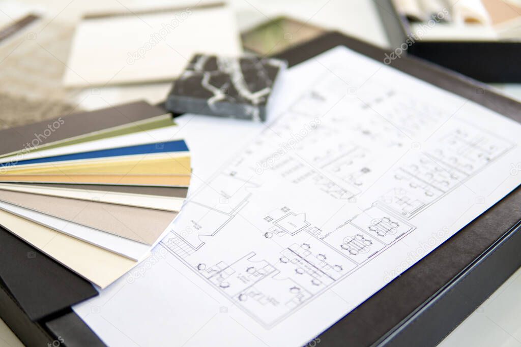 Interior designers working table, an architectural plan of the house, a color palette.