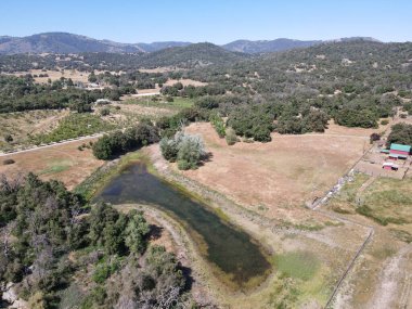San Diego 'nun doğusundaki Julian kasabasındaki tarım arazisi ile orman arasındaki vadideki küçük göl manzarası., 