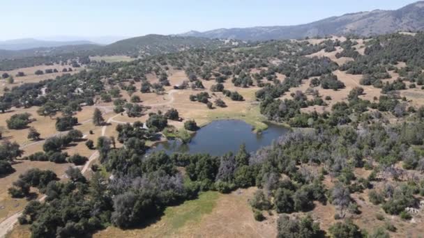 Vista aérea de pequeno lago no vale, entre terras agrícolas e floresta na cidade de Julian, a leste de San Diego, — Vídeo de Stock