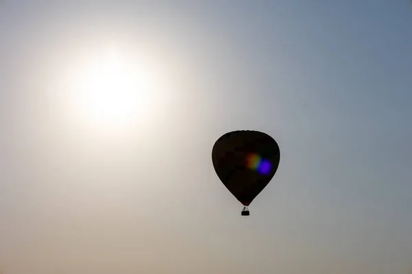 Balon cu aer cald deasupra norului în timpul apusului de soare — Fotografie, imagine de stoc