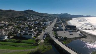 Cayucos, California USA, Pier ve Ocean Ave ve Shoreline Beach ile San Luis Obispo County 'deki Green Hills ve Central Coast' un havadan görüntüsü. Yüksek kalite 4k görüntü