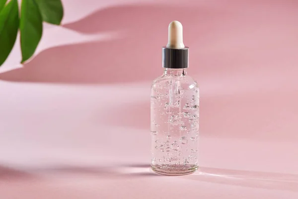 ピンクの背景にガラス瓶の中のアンチエイジング血清 コラーゲンとペプチドを含む顔液血清 美しい健康な肌のための自然なスキンケアエッセンス — ストック写真