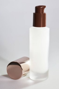 Boş, şeffaf cam bir serum şişesi ve gri bir arka planda salyangoz yüzü var. Cilt bakımlı güzellik markası. Salyangoz özü kozmetik reklamları