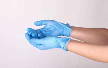 Doktor ya da hemşire mavi nitril cerrahi eldiven, profesyonel tıbbi güvenlik ve beyaz arka plan için hijyen ve sağlık muayenesi yapıyor..