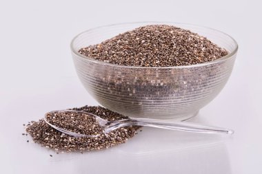 Şeffaf cam kasede beyaz arka planda izole edilmiş sağlıklı Chia tohumları.