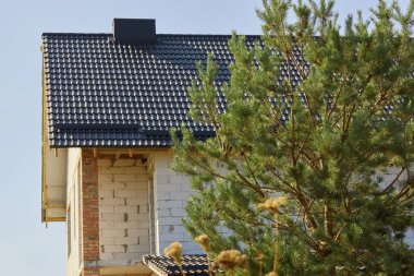 Gökyüzüne karşı bacası olan müstakil bir evin yeni çatısı. Dış bina tasarımı. 