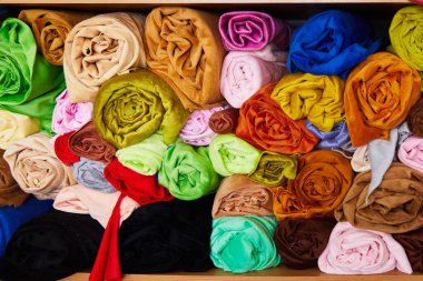 Pile of vibrant colorful rolled up fleece textile. Fabric for toys design