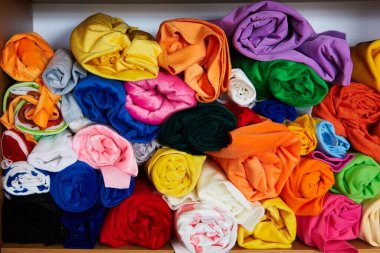 Pile of vibrant colorful rolled up fleece textile. Fabric for toys design