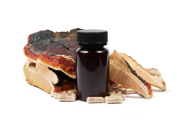 Siyah şişeli Ganoderma lucidum kapsülleri ve dilimlenmiş taze Ling zhi mantarı (Reishi mantarı veya Lingzhi mantarı olarak da bilinir) beyaz arka planda izole edilmiştir.. 