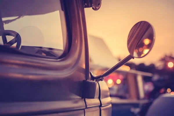 Retro truck under sunset with boken light of shop and reflect in truck side mirror, vintage style