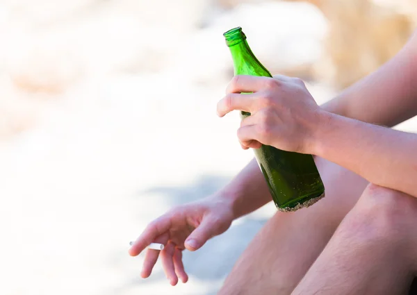 Man drinking and smoking on the beach — Stock Photo, Image