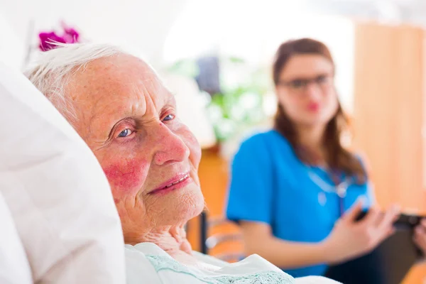 Happy senior kvinna med sjuksköterska — Stockfoto