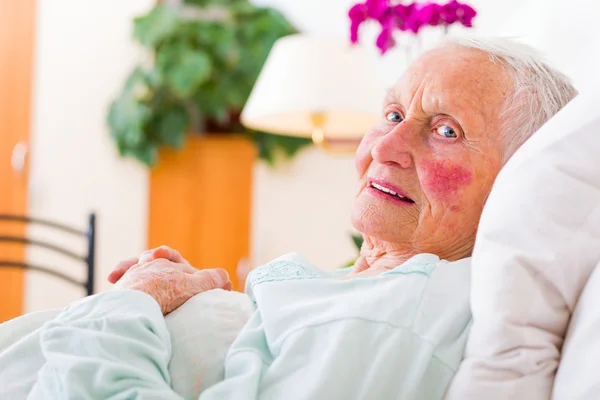 Ältere Patientin liegt im Bett — Stockfoto