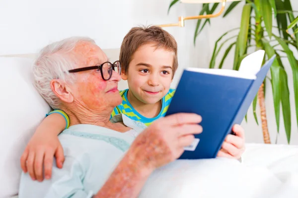 Großmutter liest ihrem Enkel Geschichten vor — Stockfoto