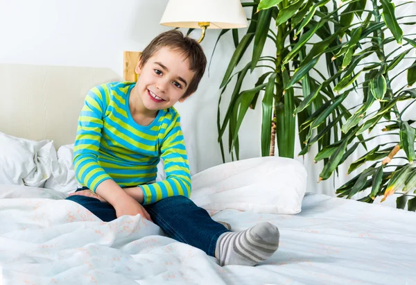 Glückliches Kind, das morgens im Bett lächelt — Stockfoto