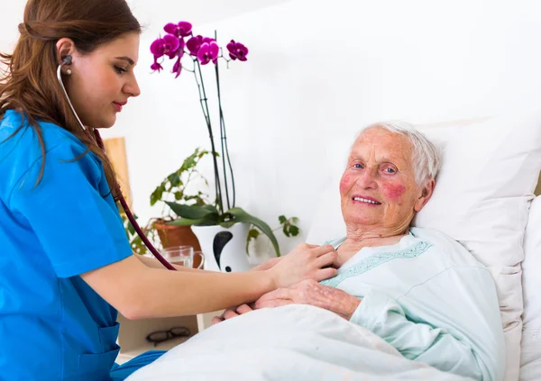 Gelukkig bejaarde vrouw bijgestaan door geriartric arts — Stockfoto