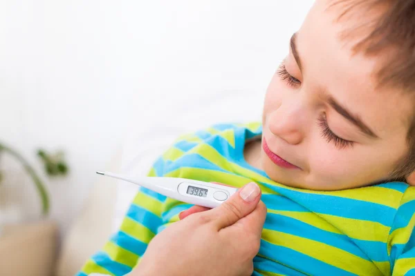 Sick boy, při pohledu na digitální teploměr — Stock fotografie