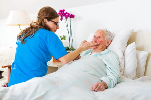 Hilfsbereite Krankenschwester kümmert sich um die Seniorin — Stockfoto