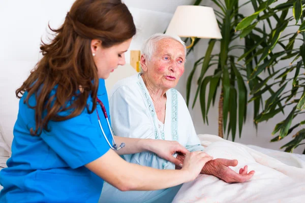 Старшая женщина разговаривает с медсестрой — стоковое фото