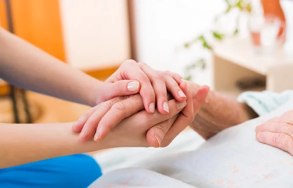 Yaşlı bir kadın elini tutarak hemşire