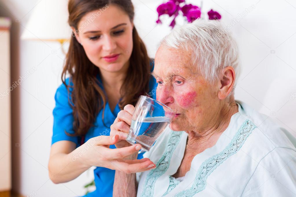 Caring nurse helping sick elderly woman Stock Photo by ©Lighthunter