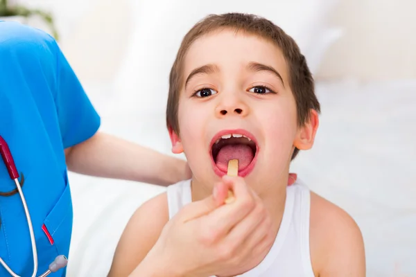 Pediatrician examining little boys throat Stock Photo