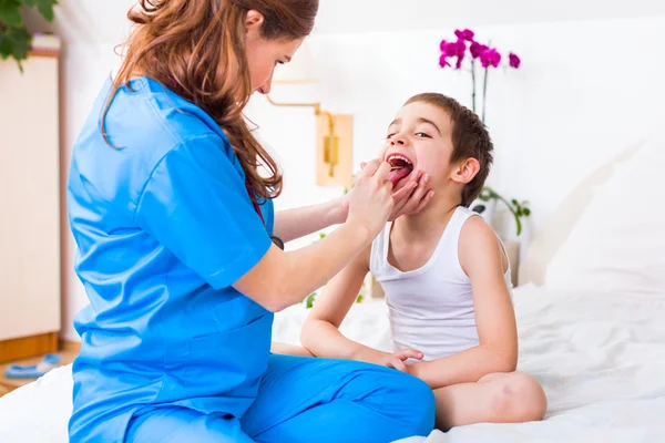 Médico olhando e examinando a garganta da criança — Fotografia de Stock