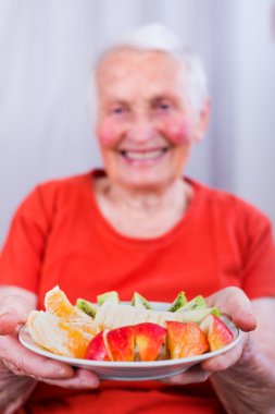 Old woman having a healty meal clipart