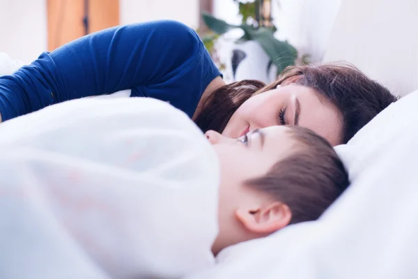 Trött mamma sova bredvid barnet — Stockfoto
