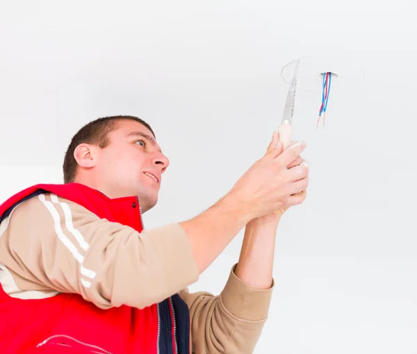 Electricista es ntalling luz en una pared — Foto de Stock