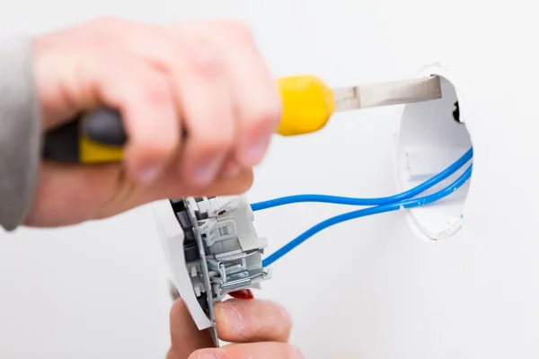 Eletricista usando ferramentas para instalar luz — Fotografia de Stock