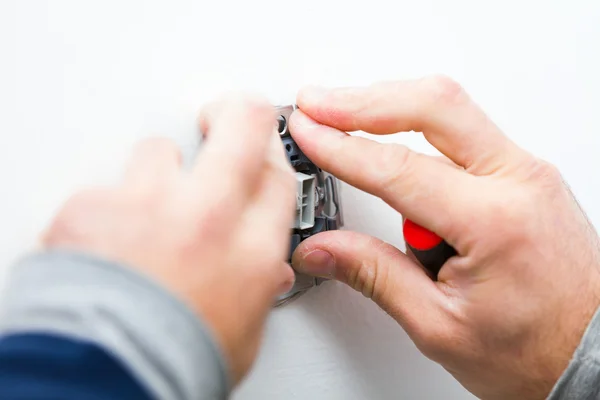 Elettricista che installa la luce su una parete — Foto Stock