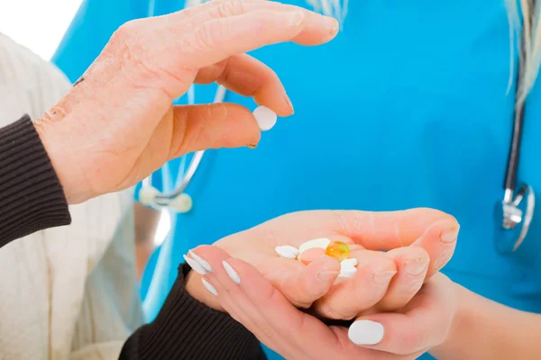 Kvinna plocka ett piller från hennes händer — Stockfoto