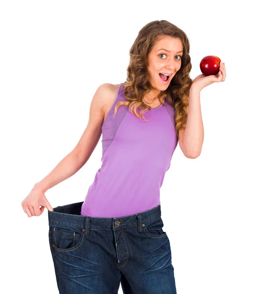 Kvinna med stora byxor håller apple — Stockfoto