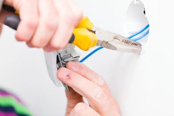 Electrician using tools for installing light — Stock Photo, Image
