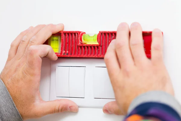 Elektricien installeren van licht op de muur — Stockfoto