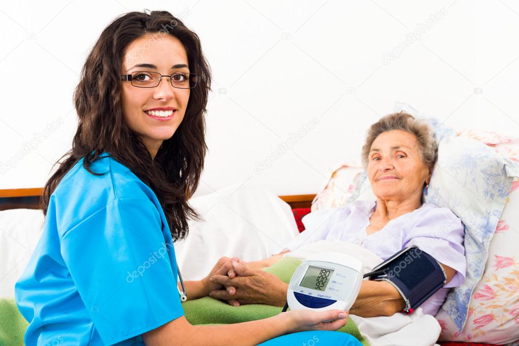 nurse measuring elderly patient's blood pressure