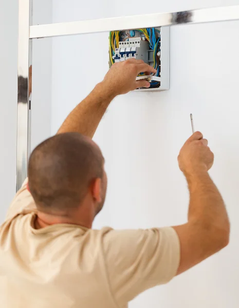 Homme électricien installant fusible électrique à la maison — Photo