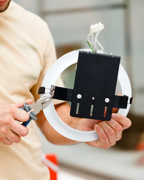 Elektricien werken met een tang een licht montage — Stockfoto