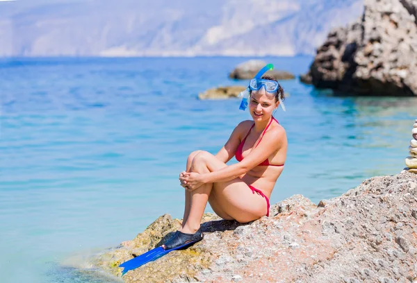 Donna in attrezzatura da snorkeling seduta su rocce — Foto Stock